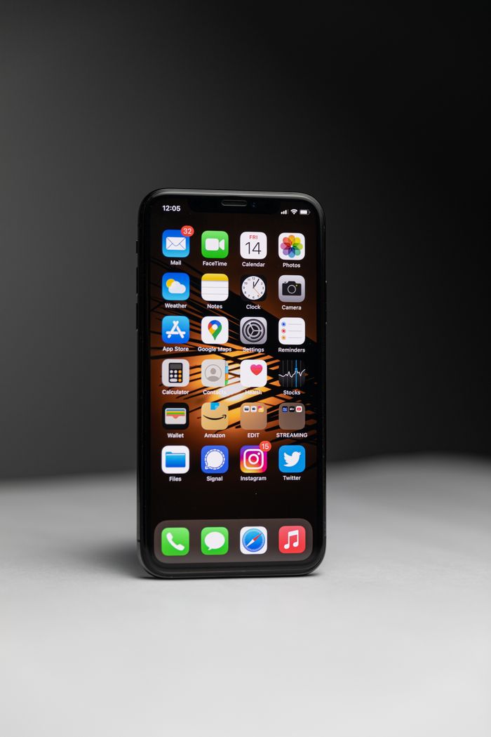 About Close-up of a smartphone with an array of app icons against dark background.