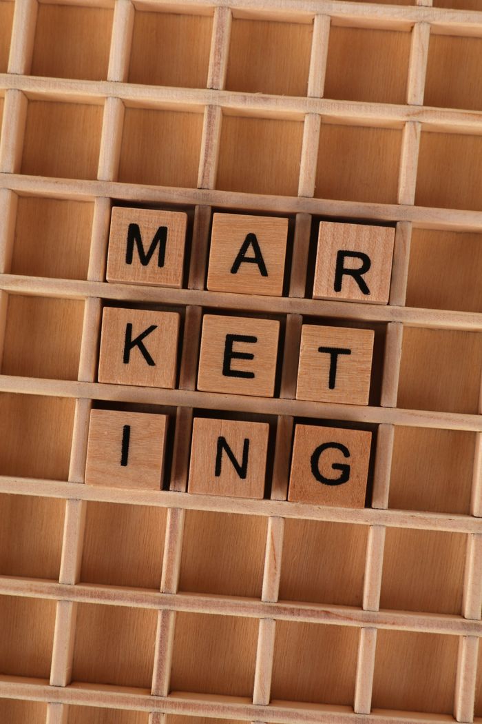 Services Wooden letter tiles arranged to spell 'marketing' on a wooden grid, depicting business strategy.