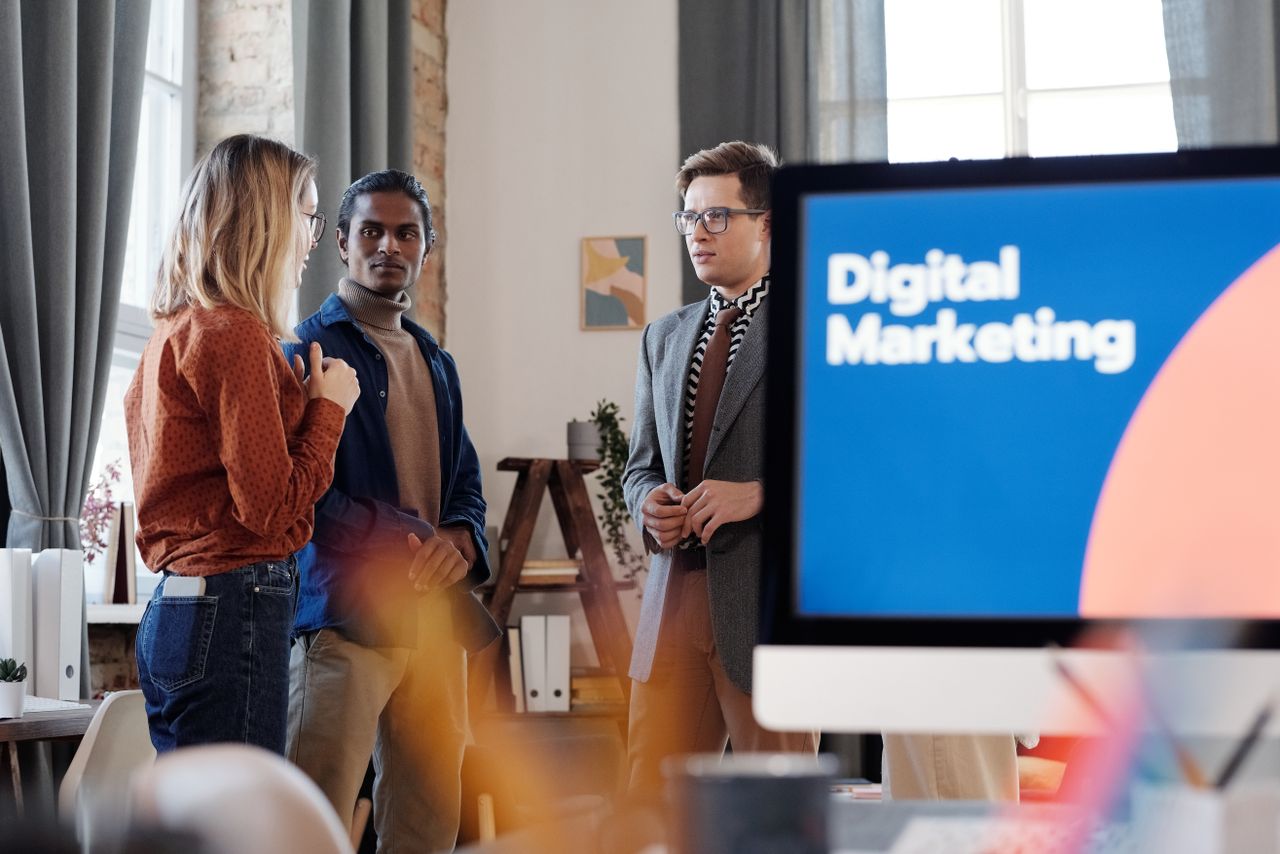 Services Group of colleagues discussing digital marketing strategies in an office setting.